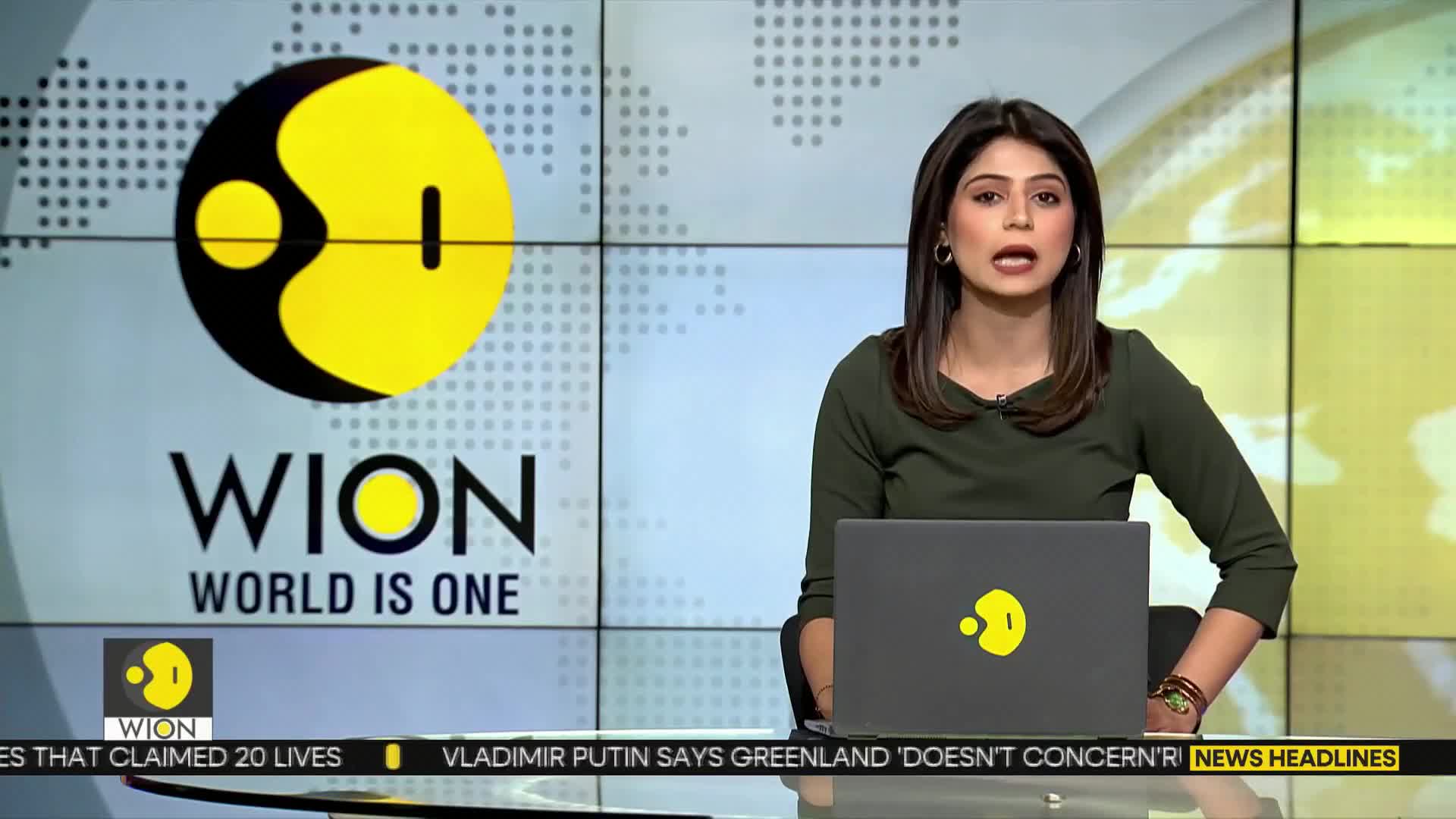 A woman in a dark green top speaks directly to the camera, her hands resting on a laptop. Behind her, the WION logo and "WORLD IS ONE" are displayed on a grid of screens.