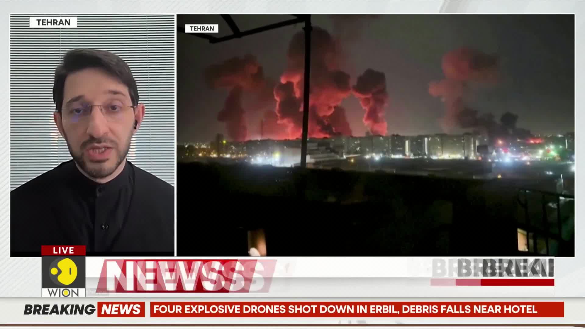 Explosions bloom in the night sky, painting the clouds a fiery red. Below, the city lights twinkle against the dark horizon.