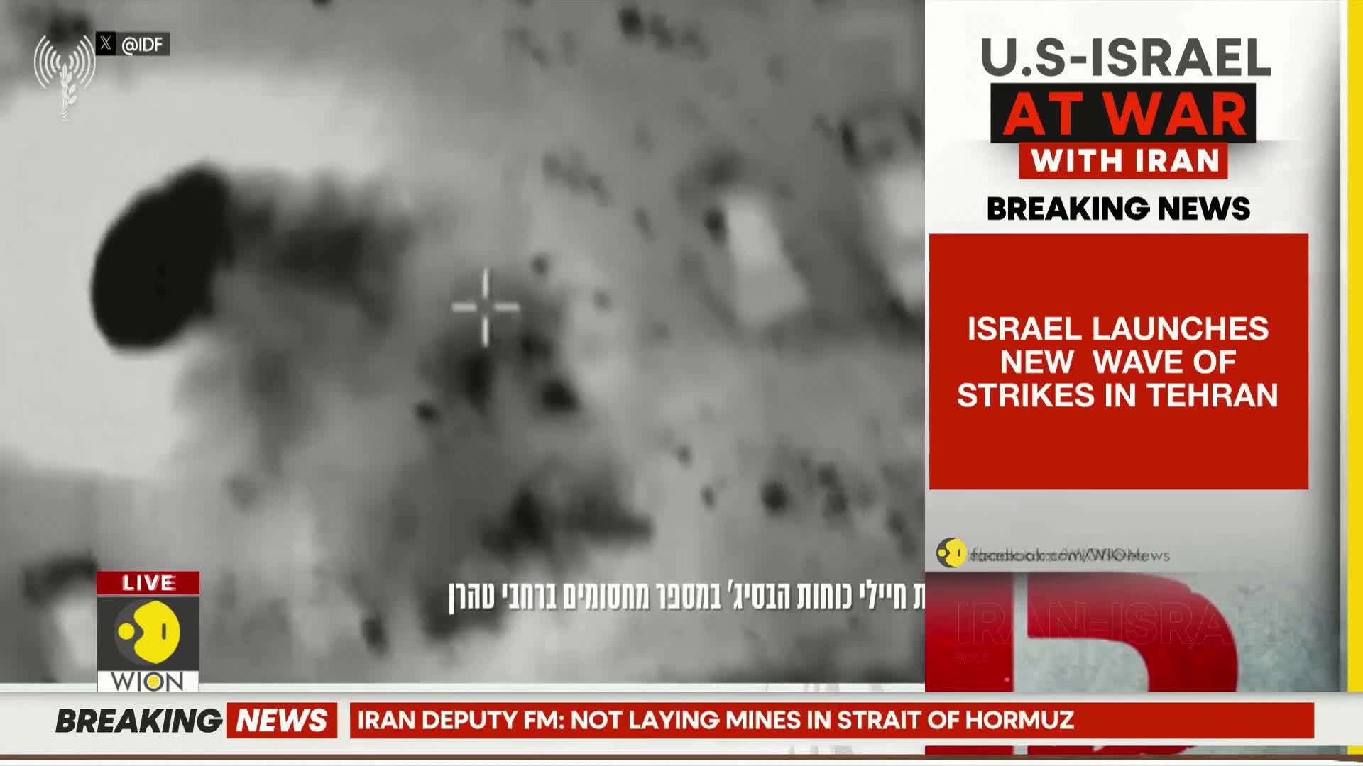 A thermal camera captures an explosion on the ground, with smoke billowing upwards. A news ticker at the bottom of the screen reports on the ongoing conflict.