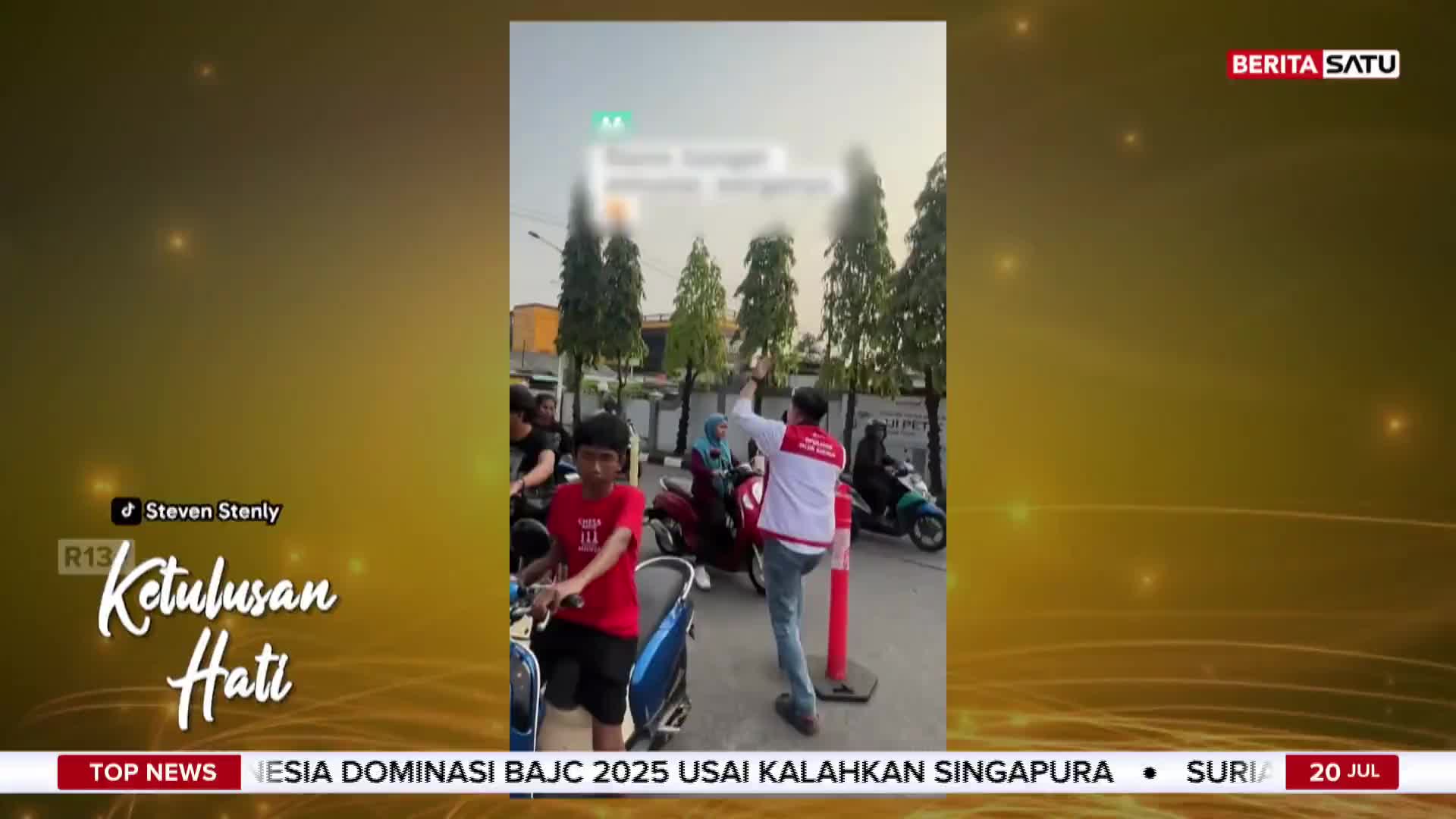 A man in a red and white shirt gestures with his hand, seemingly directing traffic near a row of scooters. The scene is broadcast on BeritaSatu English, with a headline about Indonesia.
