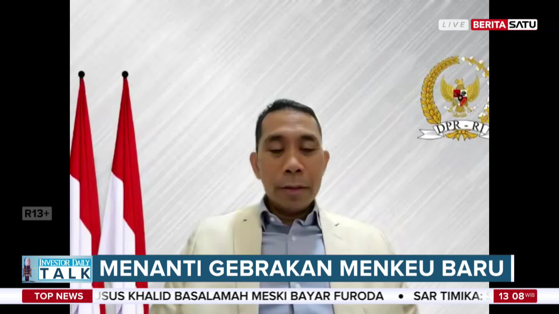 A man in a light jacket and blue shirt speaks directly to the camera, framed by two Indonesian flags and the BeritaSatu English logo. The broadcast, "Investor Daily Talk," is discussing the new Minister of Finance.
