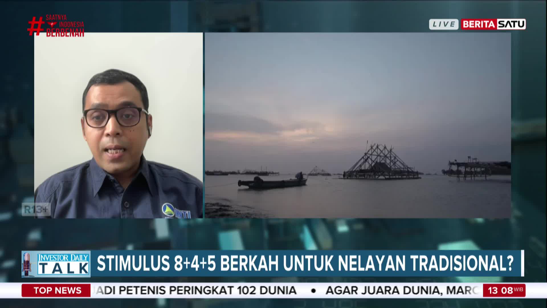 A man on BeritaSatu English is discussing stimulus for traditional fishermen, with a backdrop of fishing structures on the water. The image shows a calm sea under a dusky sky.
