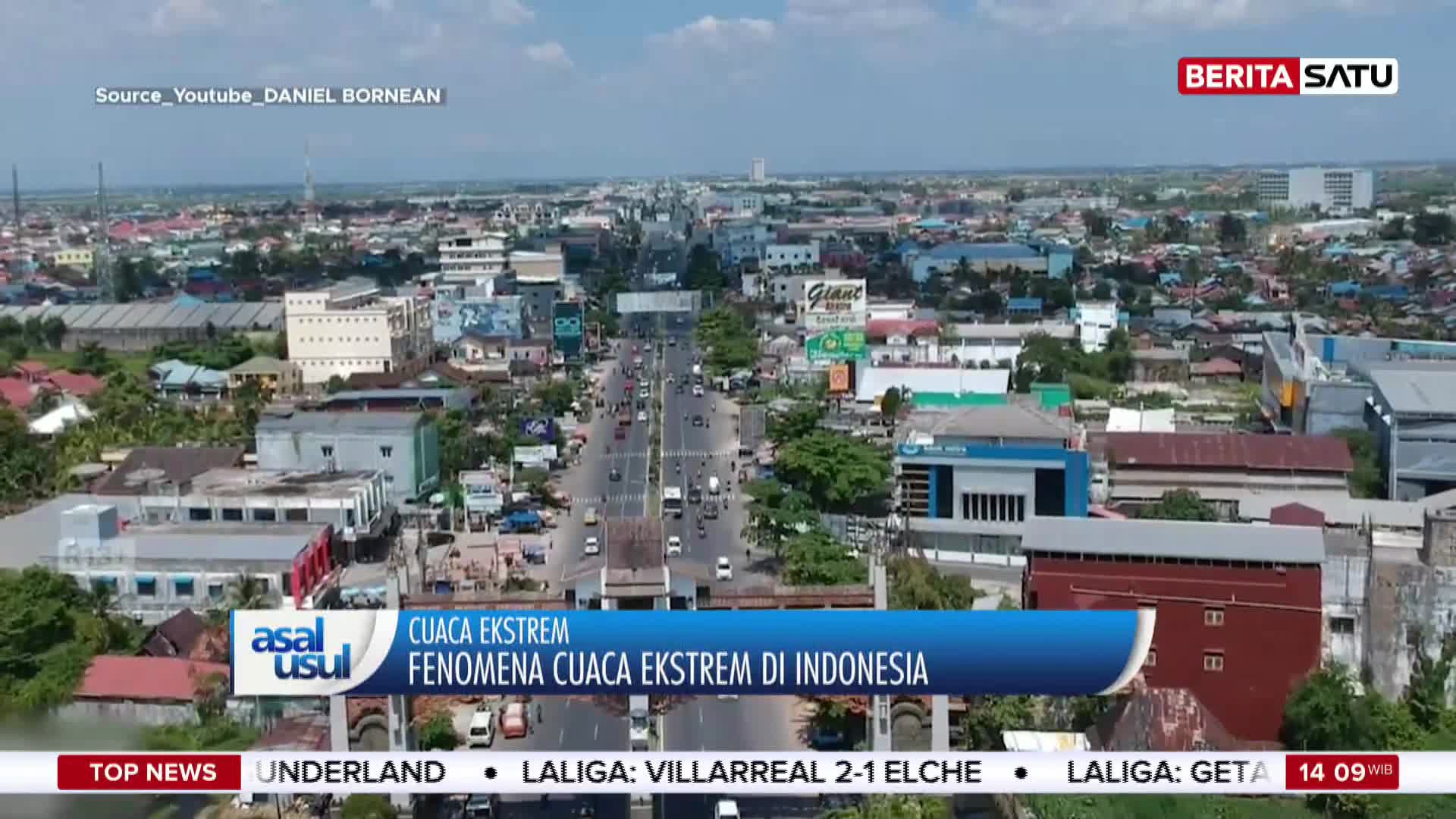 Cars and motorcycles navigate a busy street lined with buildings under a bright sky. A news banner from Berita Satu announces extreme weather phenomena in Indonesia.