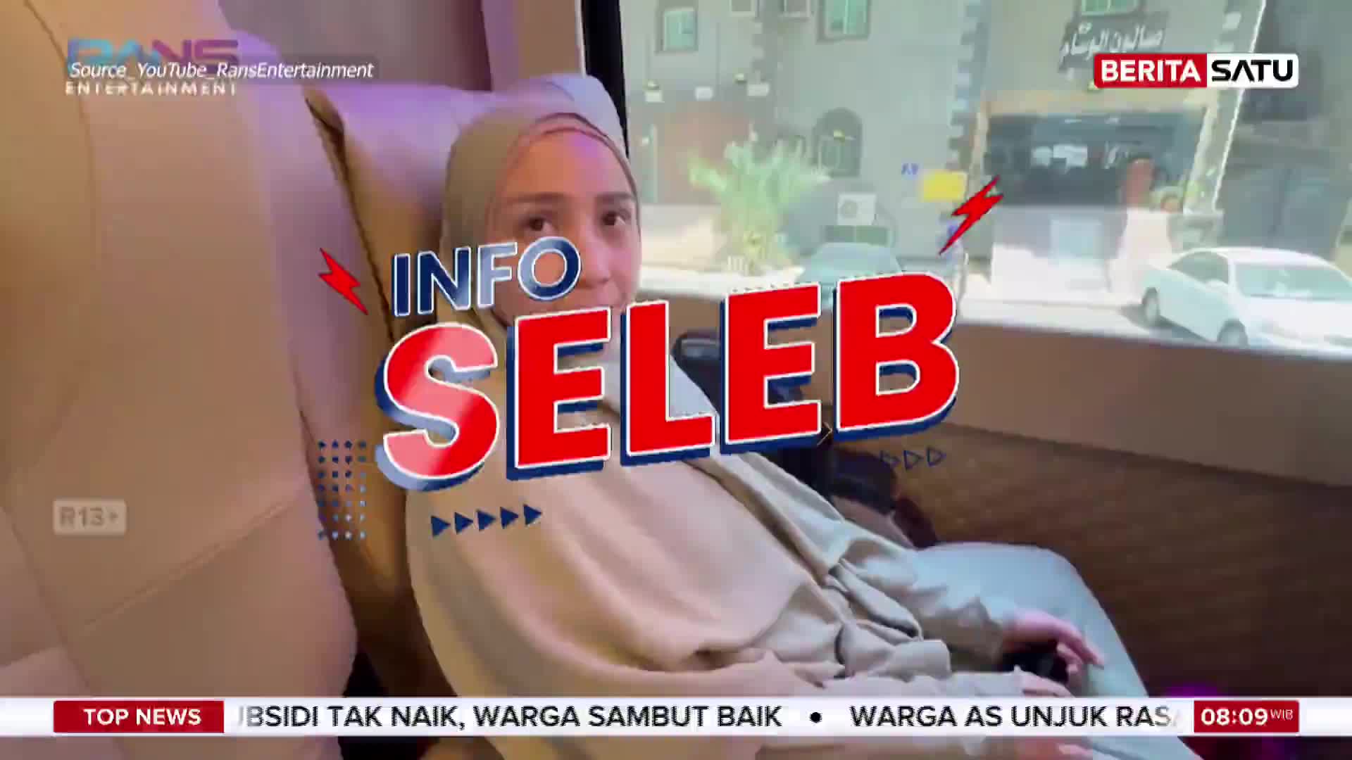 A woman in a hijab is seated in a vehicle, looking towards the camera. Large red letters spelling "INFO SELEB" overlay the scene, with a Berita Satu logo in the upper right corner.