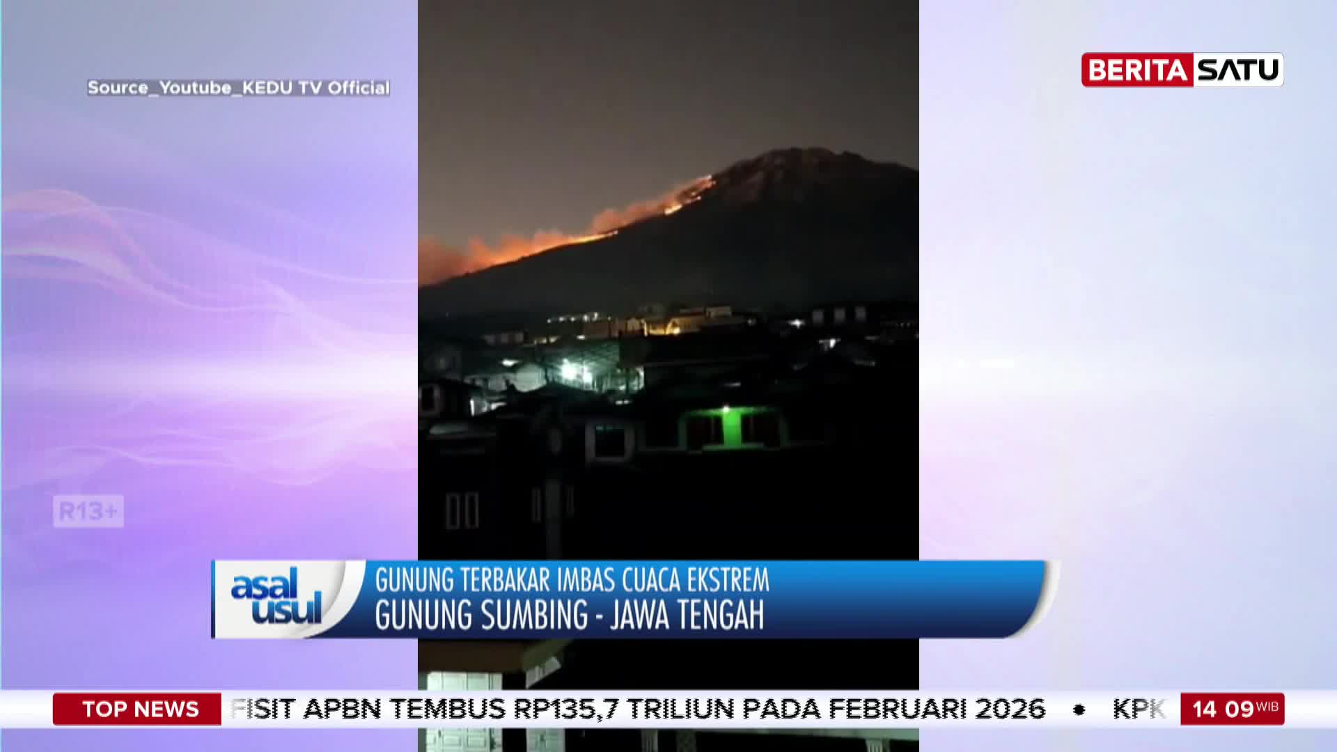 Flames lick the upper slopes of Gunung Sumbing, a stark orange against the night sky. Below, the lights of a village twinkle, seemingly unaffected by the blaze.