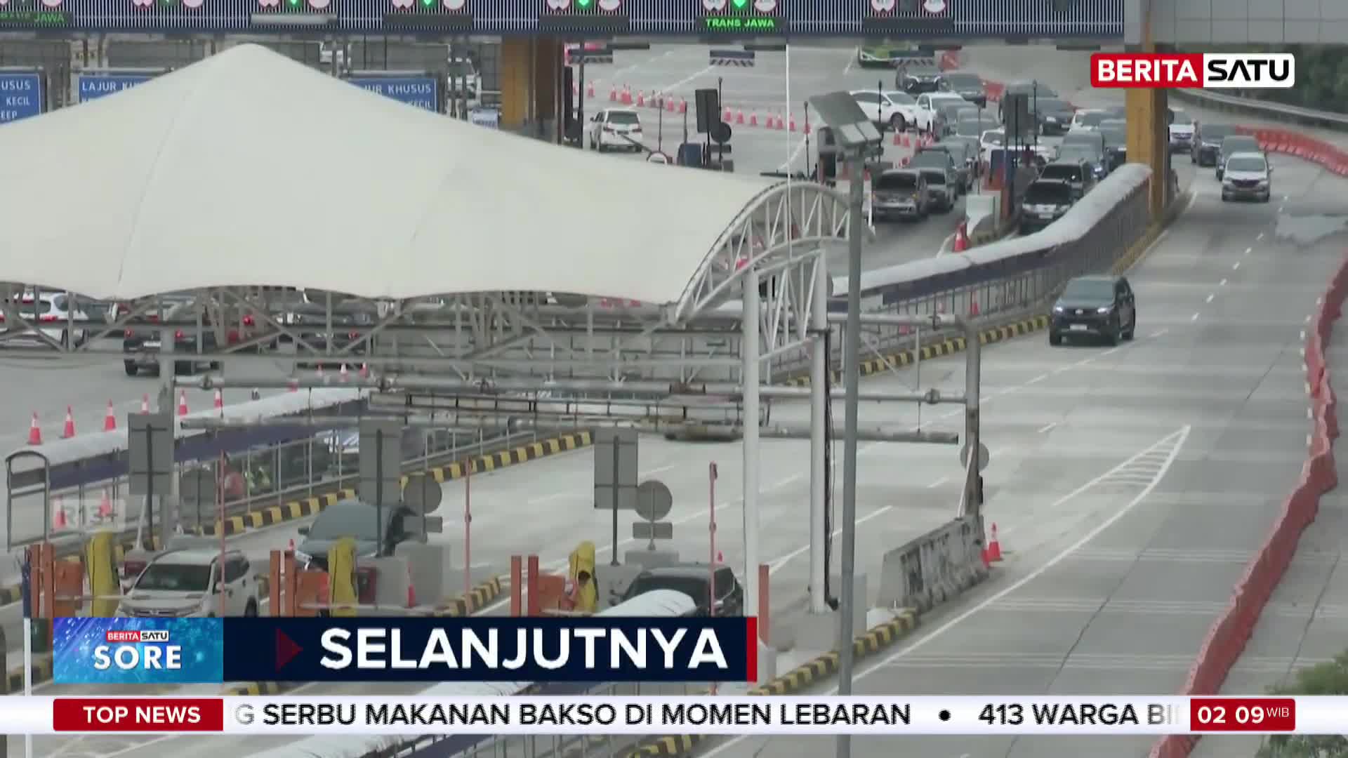 Cars are lined up at the toll gates on this Indonesian highway. A black SUV just passed through the payment booths.