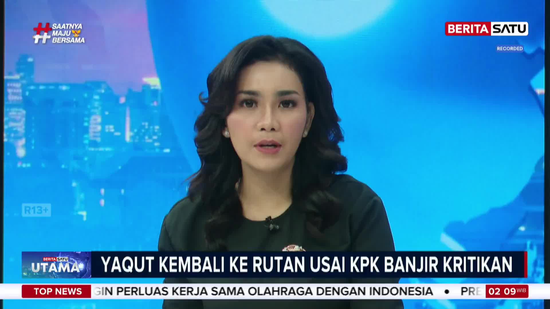 A woman with dark, wavy hair speaks directly into the camera, her expression serious. A graphic behind her displays "BERITA SATU" and "RECORDED" in red and white lettering.