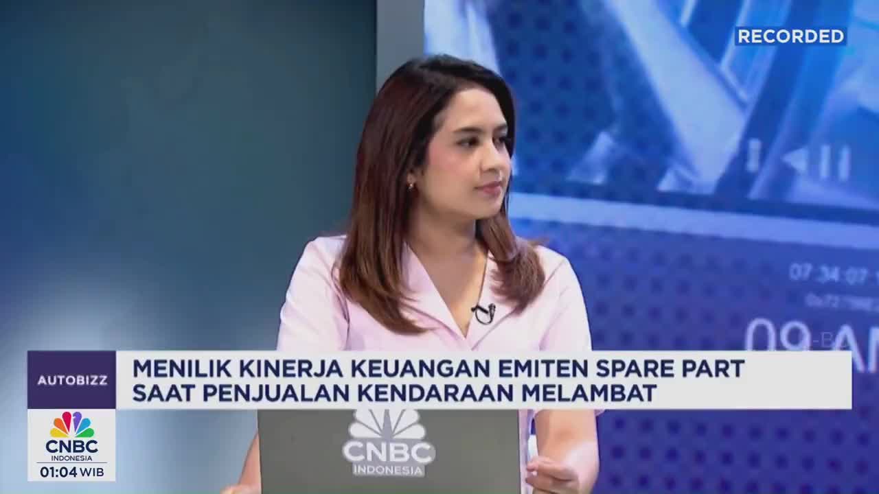 A woman in a pink shirt is speaking on a CNBC Indonesia broadcast. The lower third of the screen displays a headline about spare part sales.
