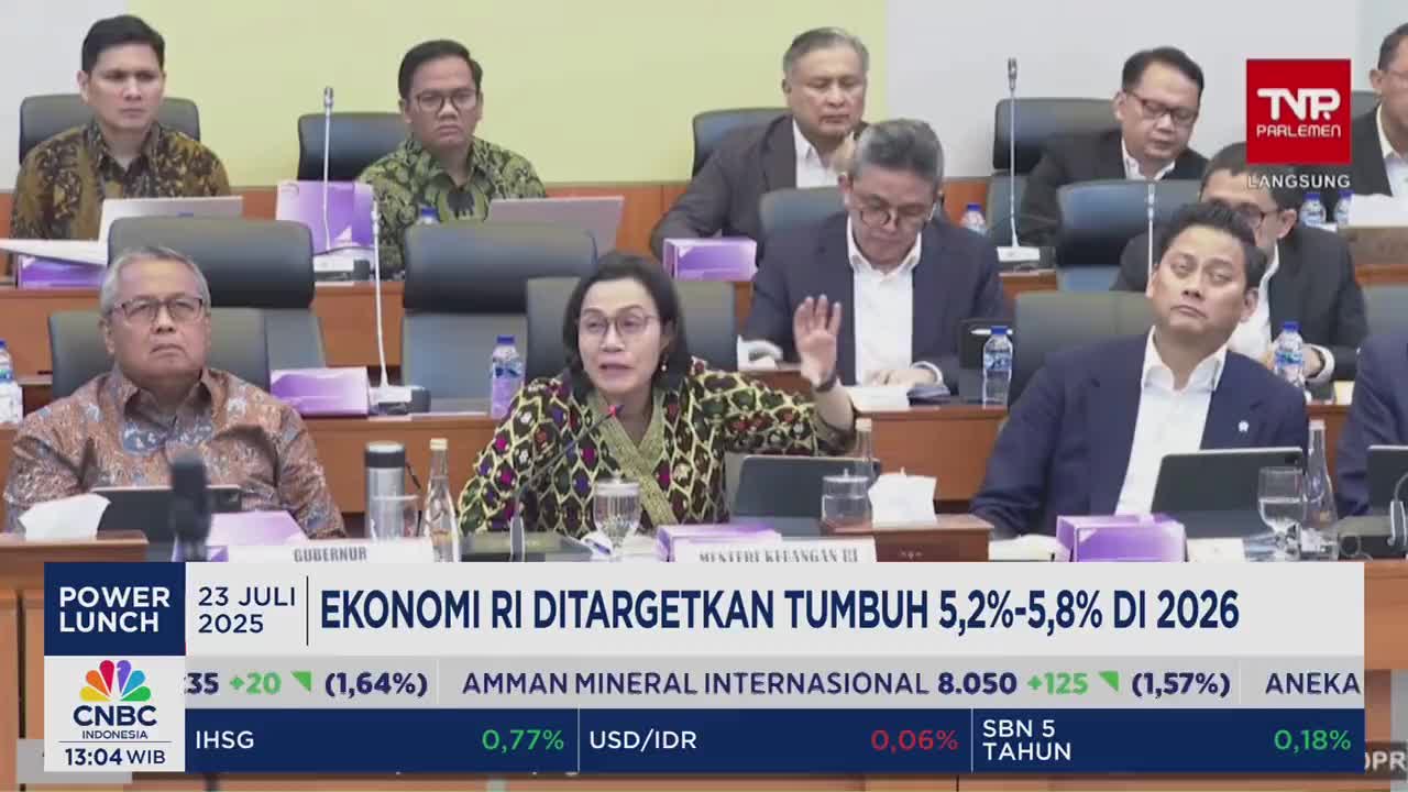 A woman in a patterned blouse gestures emphatically as she speaks, seated at a table with other officials. The CNBC Indonesia logo and financial data are displayed on the screen below.
