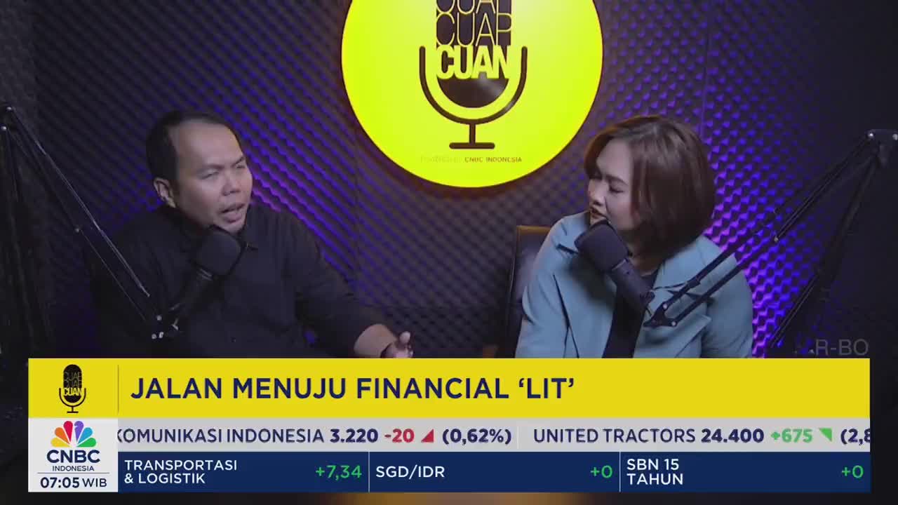 In a studio setting, two people are seated, each with a microphone, engaged in a discussion. The CNBC Indonesia logo and a financial ticker are visible at the bottom of the screen.
