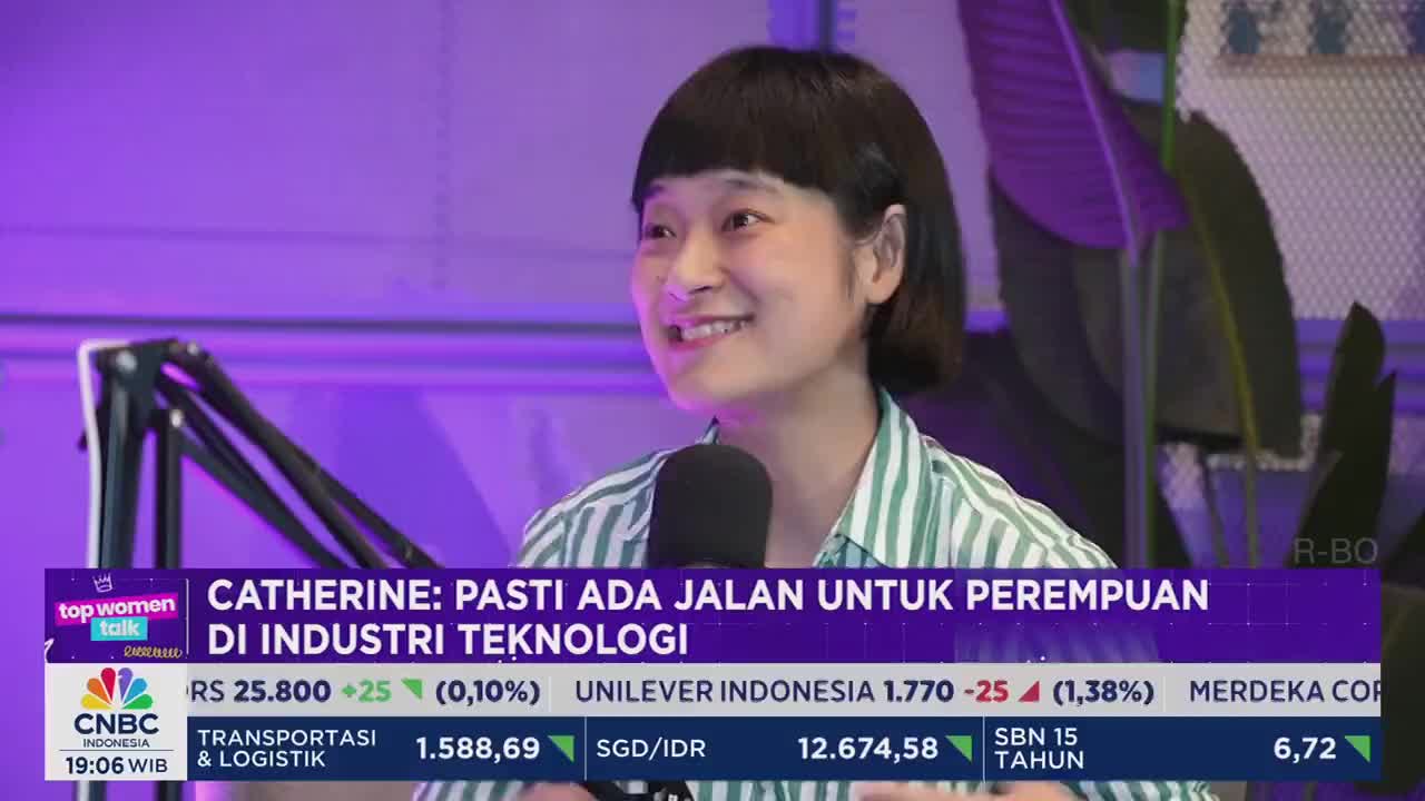 A woman with short, dark hair smiles into a microphone, speaking on a CNBC Indonesia program. The lower third of the screen displays stock market data and the show's title, "Top Women Talk."
