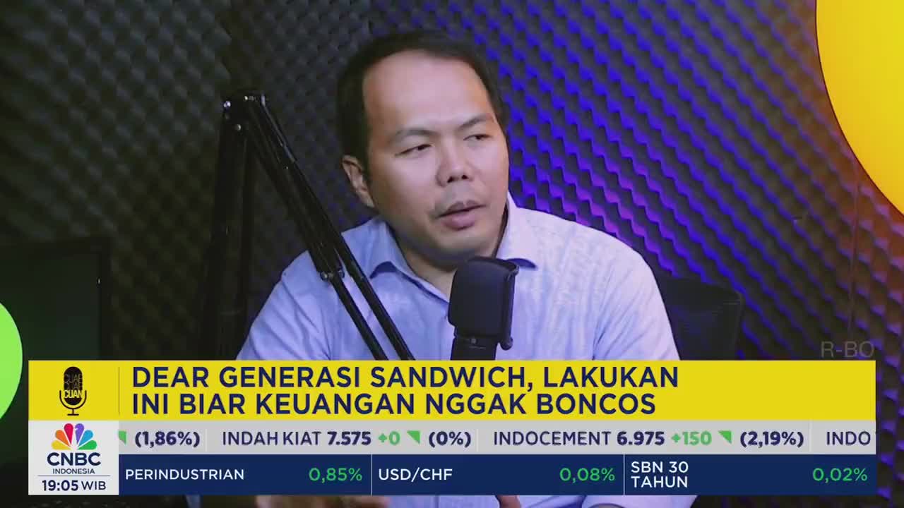 A man in a light blue shirt speaks into a microphone, his gaze directed slightly off-camera. Below, the CNBC Indonesia logo and financial data are displayed in a yellow banner.
