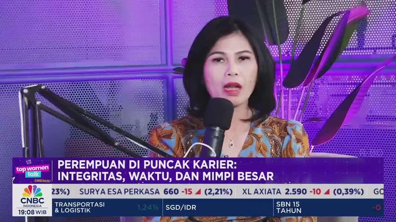 A woman with dark hair speaks into a microphone, her mouth open as she addresses the camera. The CNBC Indonesia logo is visible in the corner, along with text about women and career.
