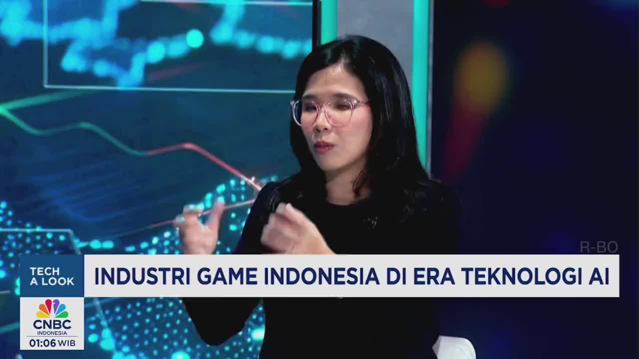 A woman on CNBC Indonesia gestures with her hands as she speaks. The lower third of the screen displays the program's title, "Industri Game Indonesia di Era Teknologi AI."
A woman on CNBC Indonesia gestures with her hands as she speaks. The lower third of the screen displays the program's title, "Industri Game Indonesia di Era Teknologi AI."