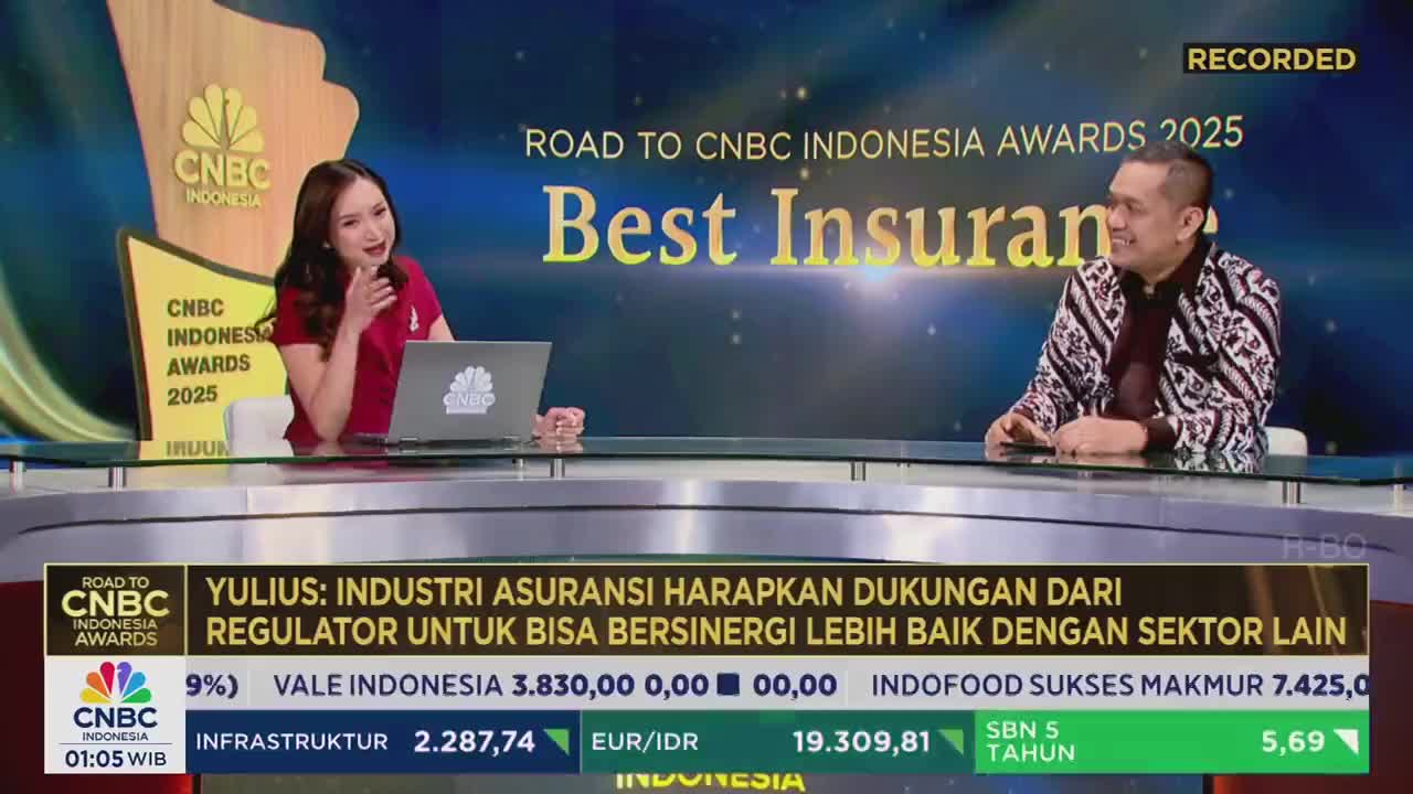 A woman in a red shirt gestures while speaking, a laptop open in front of her. Across the desk, a man in a patterned shirt smiles, likely in a CNBC Indonesia studio.
A woman in a red shirt gestures while speaking, a laptop open in front of her. Across the desk, a man in a patterned shirt smiles, likely in a CNBC Indonesia studio.