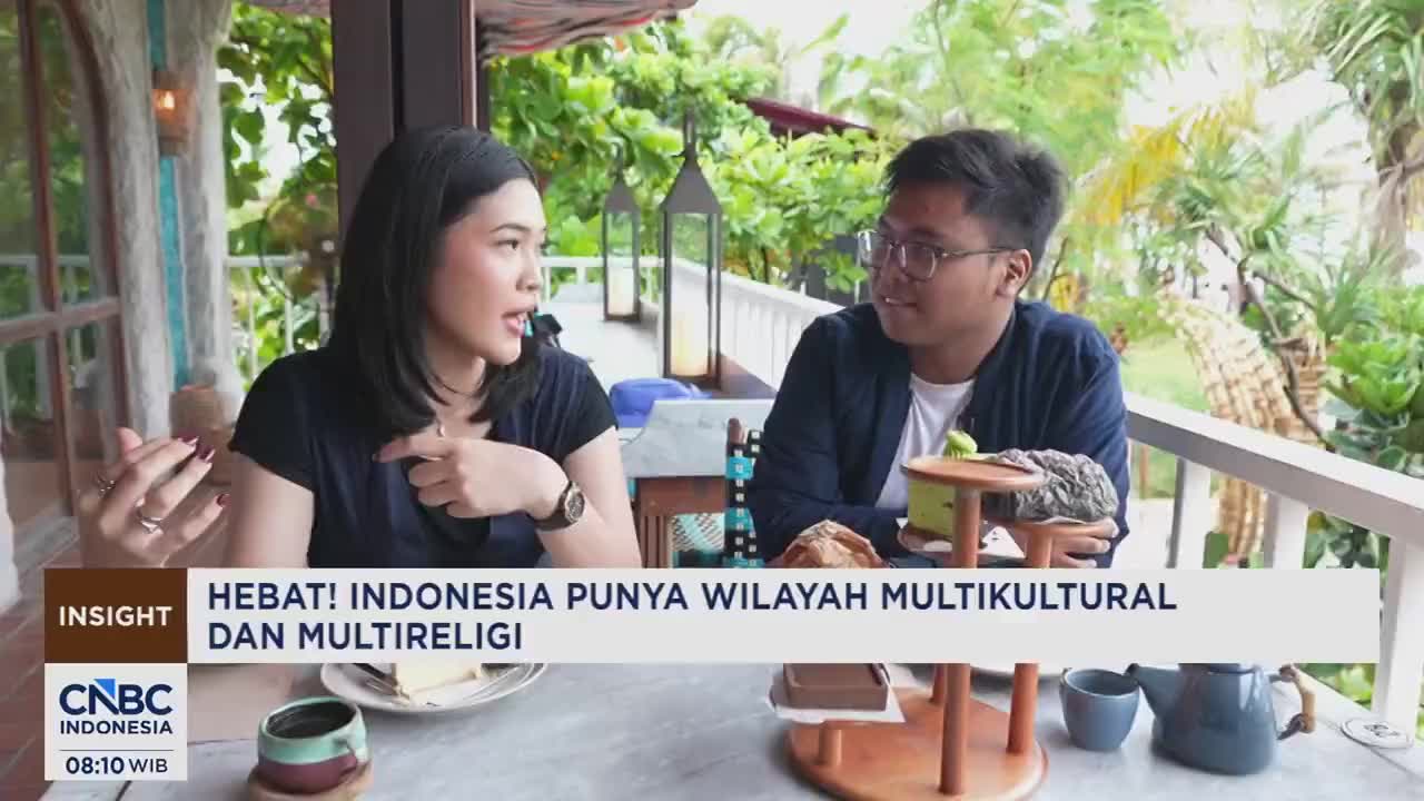 A woman and a man are seated at a table outdoors, engaged in conversation. The CNBC Indonesia logo is visible in the lower left corner.