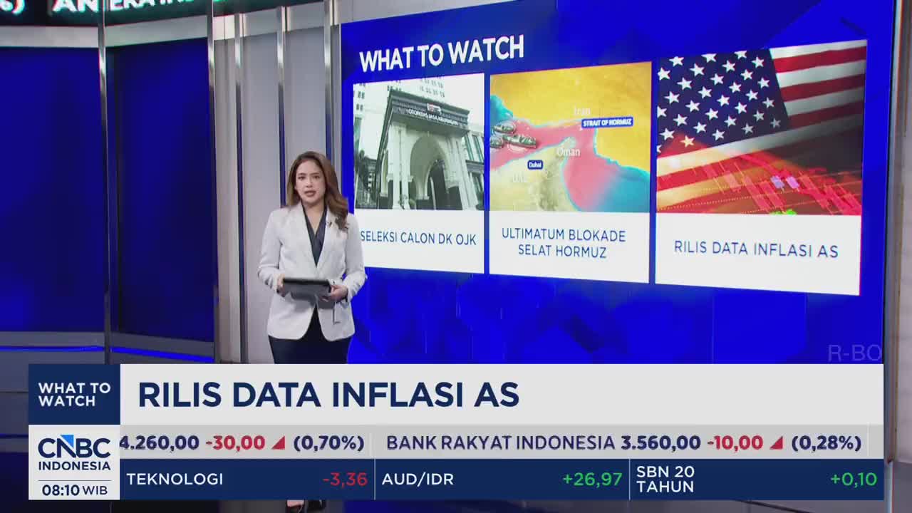 A woman in a blazer stands holding a tablet, presenting news from CNBC Indonesia. Behind her, a screen displays "WHAT TO WATCH" with three news tiles, including one about US inflation data.