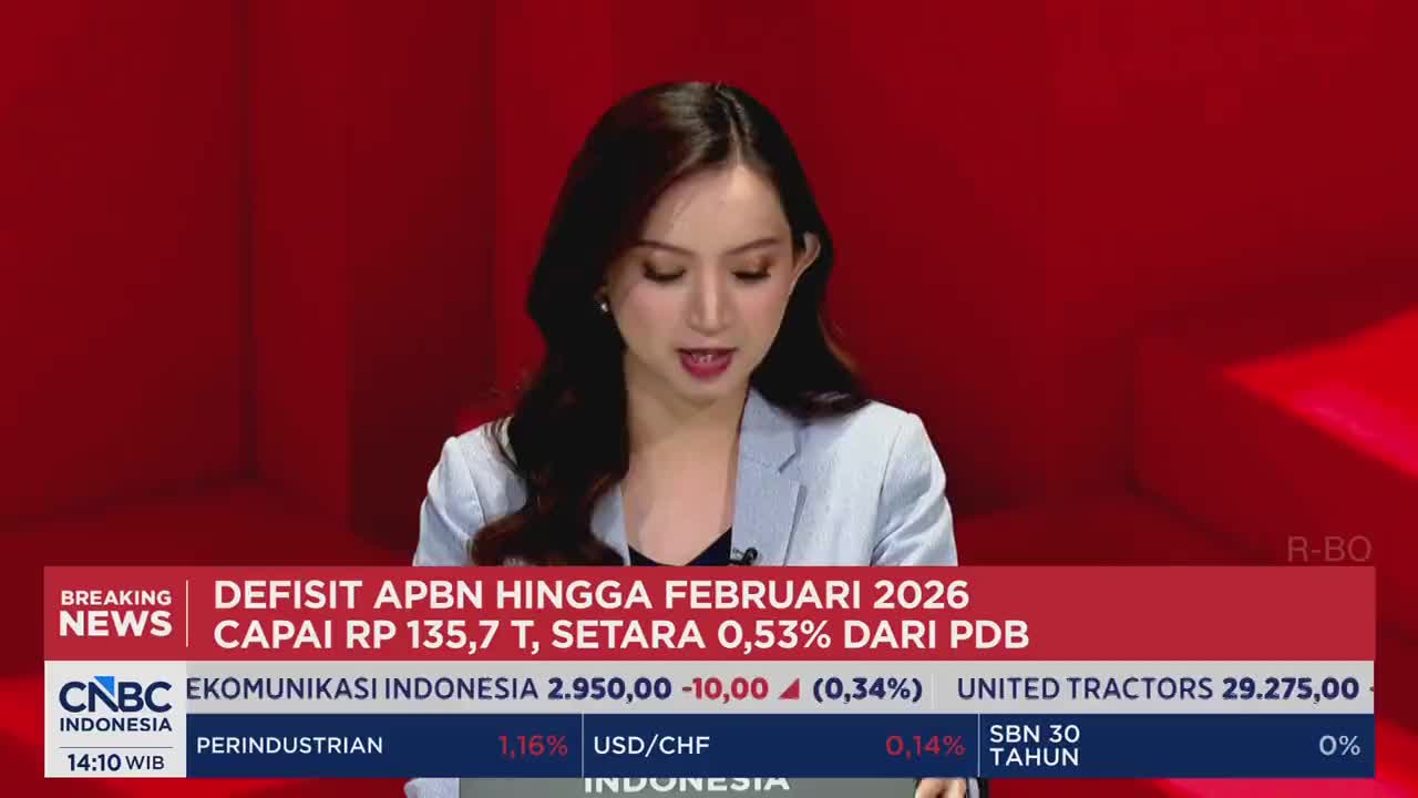 A woman in a light blazer speaks into a microphone, her gaze directed downward. Below her, a ticker displays financial data for CNBC Indonesia, including stock prices and currency exchange rates.