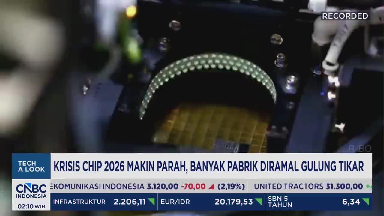 A robotic arm moves precisely over a tray of golden silicon wafers, each etched with intricate patterns. This scene unfolds as CNBC Indonesia reports on the worsening chip crisis and its impact on factories. A robotic arm moves precisely over a tray of golden silicon wafers, each etched with intricate patterns. This scene unfolds as CNBC Indonesia reports on the worsening chip crisis and its impact on factories.