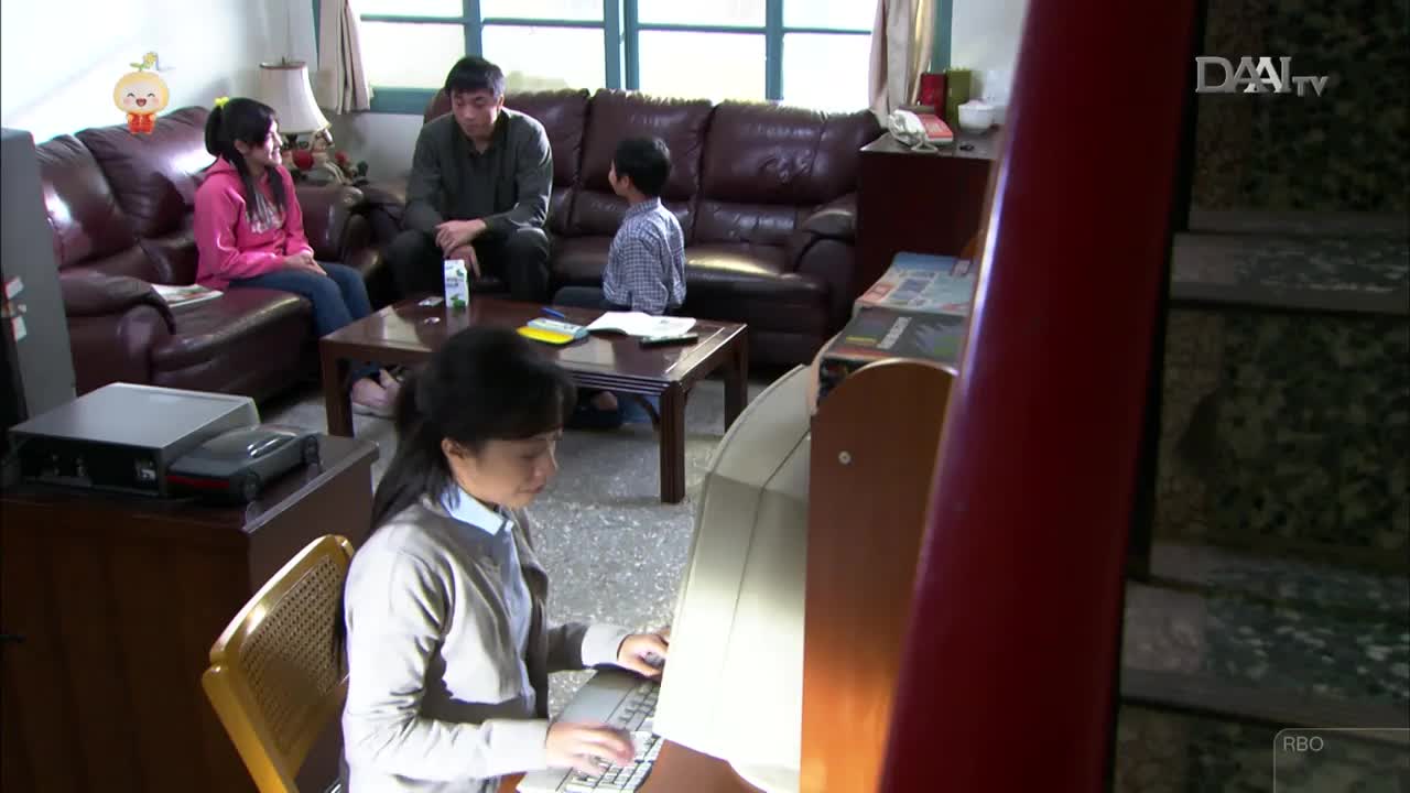 A young girl sits at a computer, her fingers poised over the keyboard. In the background, a family gathers in their living room, a common scene in many Indonesian homes, perhaps after a broadcast from DAAI TV. A young girl sits at a computer, her fingers poised over the keyboard. In the background, a family gathers in their living room, a common scene in many Indonesian homes, perhaps after a broadcast from DAAI TV.