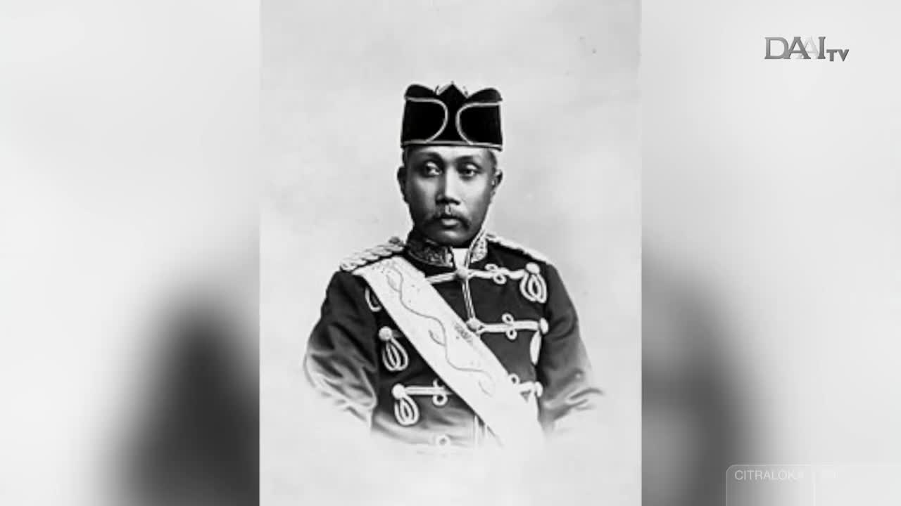 A distinguished man in a formal uniform stands before me, his gaze steady. A white sash, intricately patterned, crosses his chest, a mark of his station in this Indonesian portrait.