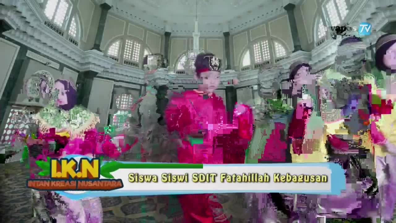 A group of students in bright costumes are in a grand hall, their images distorted with digital noise. The Jawa Pos TV logo is visible, and a banner identifies the performers as students from SDIT Fatahillah Kebagusan.
