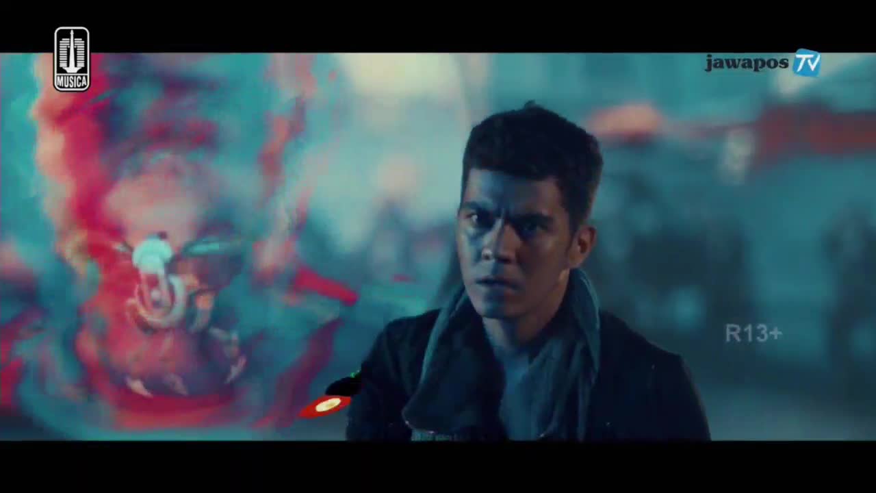 A man stares intently, his face lit by a blueish light, as a motorcycle seems to be emerging from a cloud of red and teal. The Jawa Pos TV logo sits in the corner.

