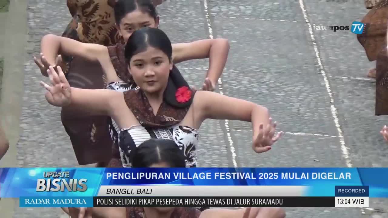 Young women, dressed in traditional Balinese attire, gracefully move their hands in a synchronized dance. The Jawa Pos TV broadcast shows the Penglipuran Village Festival in Bangli, Bali, underway.
