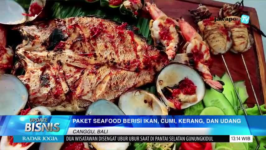 A platter of grilled seafood sits before me, including a whole fish and skewered squid, all glistening with a red sauce. The Jawa Pos TV logo is visible in the corner, and the bottom banner mentions Canggu, Bali.
