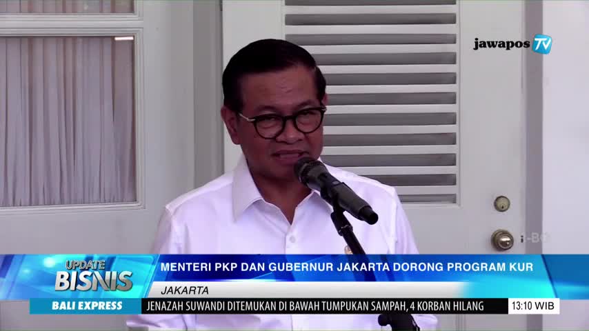 A man in glasses speaks into a microphone, likely on Jawa Pos TV, with the news ticker below. The screen displays "Update Bisnis" and a headline about Jakarta, Indonesia.
