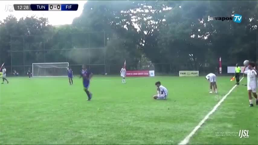 A player in purple sprints downfield, while another sits on the grass, seemingly injured. The score is tied, as Jawa Pos TV broadcasts the match from Indonesia.
