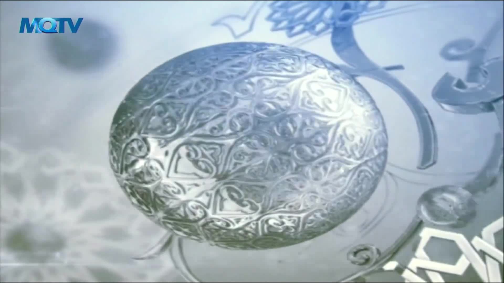 A detailed, silvery sphere with intricate patterns floats against a soft, blue-grey background. The MQTV logo is visible in the upper left corner.
