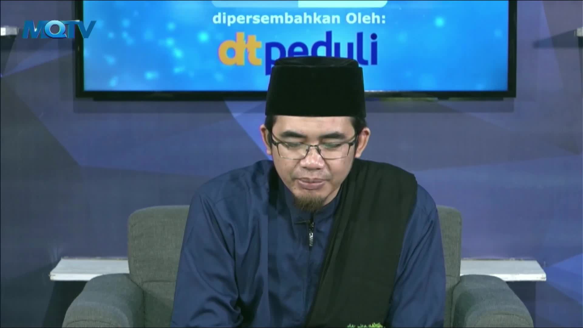 The man in the black cap and glasses sits in a chair, looking down. Behind him, the MQTV logo and a screen with the "dtpeduli" logo are visible.
