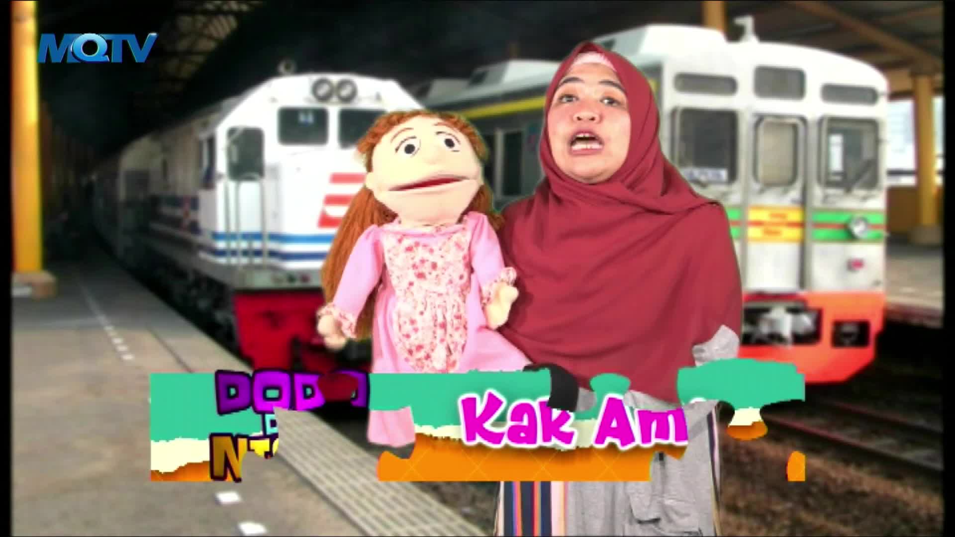 A woman in a red hijab and a puppet stand in front of a train, a backdrop for an Indonesian children's show on MQTV. The show's title is emblazoned on a colorful graphic at the bottom of the screen.
