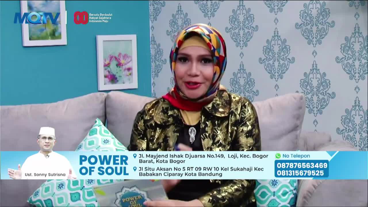 A woman in a colorful headscarf and gold-patterned jacket is speaking, seated on a couch. Beneath her, a banner for "Power of Soul" on MQTV in Indonesia displays contact information.

