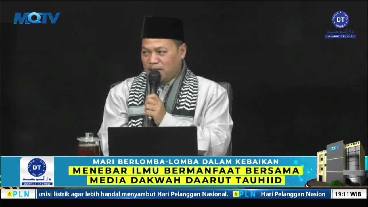 A man in a black cap and white robe speaks into a microphone, his words broadcast on MQTV. Below, a banner promotes a "Media Dakwah Daarut Tauhiid" event.
