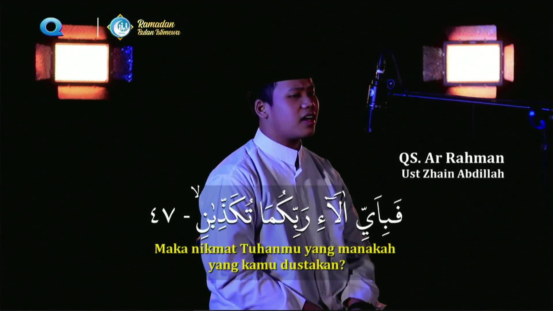 A man in a white robe and peci recites verses from the Quran, his voice amplified by a microphone. Arabic script and Indonesian subtitles appear on screen, indicating this is a broadcast from MQTV during Ramadan in Indonesia.