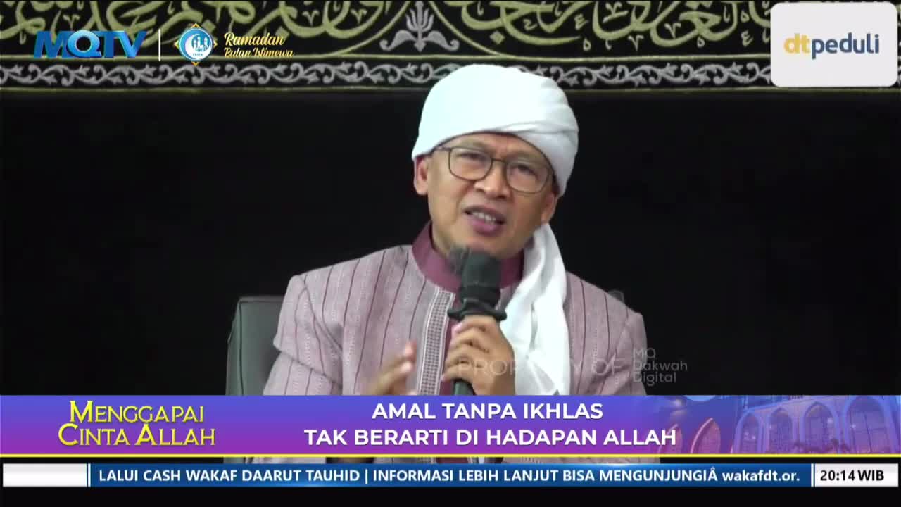 A man in a white turban and a patterned shirt speaks into a microphone, gesturing with his hands. A banner below displays text in Indonesian, indicating this is a broadcast from MQTV.