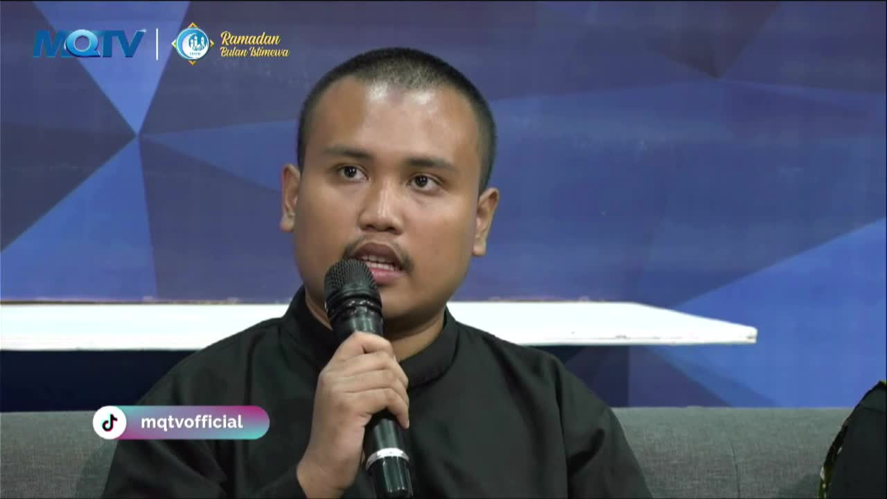 A man speaks into a microphone, his face illuminated by studio lights. The MQTV logo and "Ramadan Bulan Istimewa" text are visible behind him.