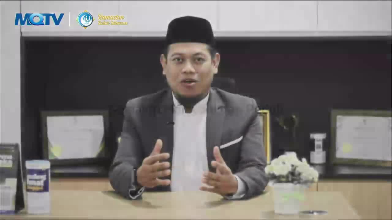 A man in a suit and peci speaks animatedly, gesturing with his hands. The MQTV logo is visible in the upper left corner.