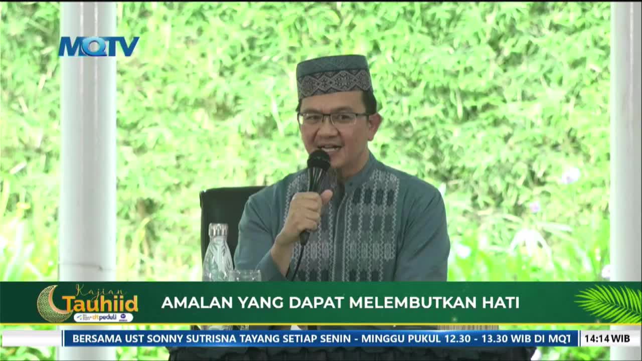 A man in a peci cap and glasses speaks into a microphone, his mouth open in mid-sentence. The MQTV logo is visible in the upper left corner, and a green banner below displays text in Indonesian.