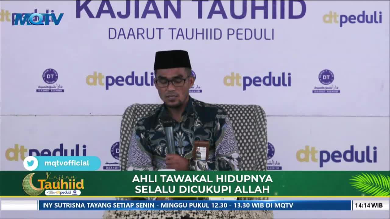 A man in a black peci and glasses speaks into a microphone, seated on a patterned chair. The backdrop behind him features the MQTV logo and the words "DAARUT TAUHIID PEDULI."