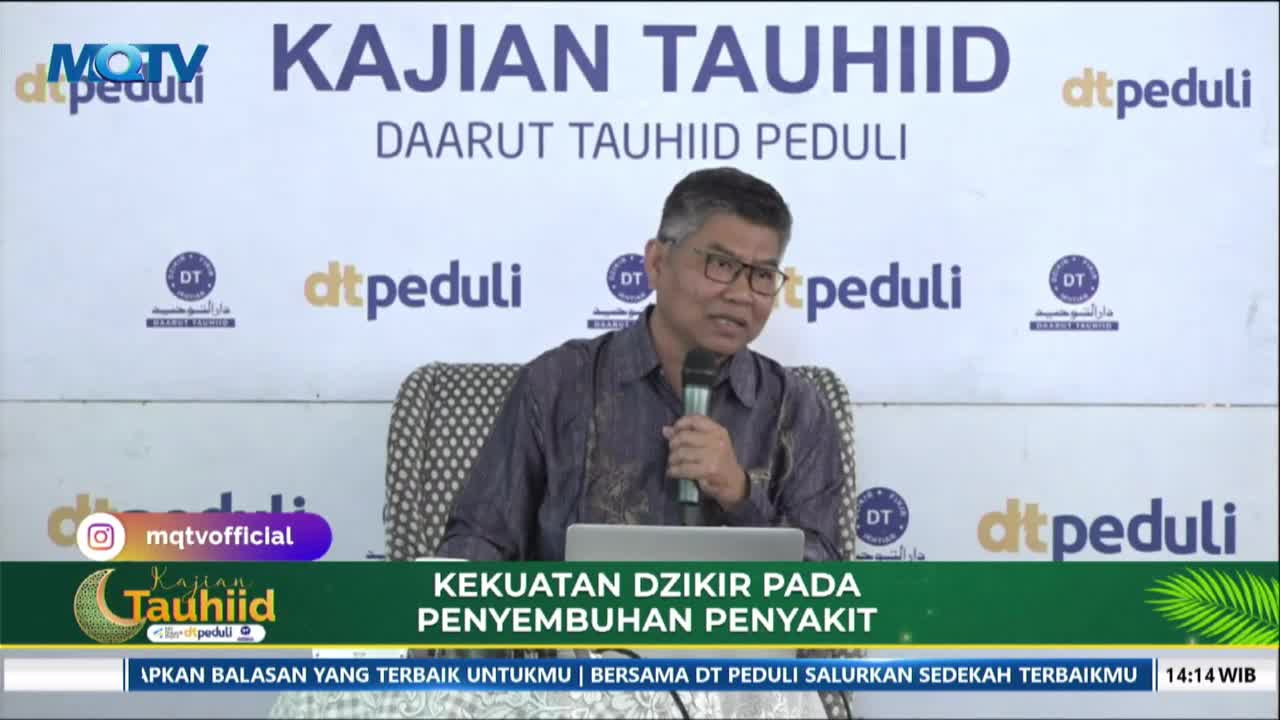 A man speaks into a microphone at a podium, a laptop open before him. The backdrop behind him displays the words "KAJIAN TAUHIID DAARUT TAUHIID PEDULI" and several logos.