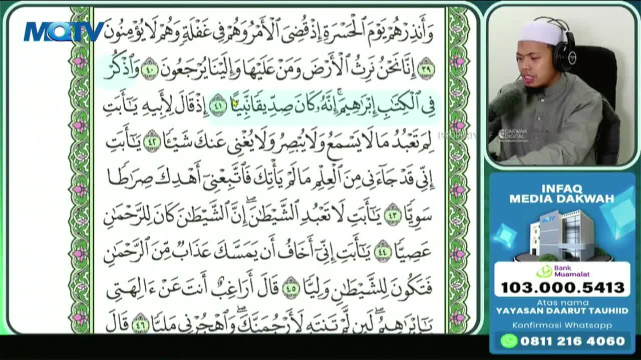 A man in a white cap and headphones speaks into a microphone, his face illuminated by the screen. To his left, Arabic script scrolls by on a green background, a familiar sight on MQTV broadcasts.