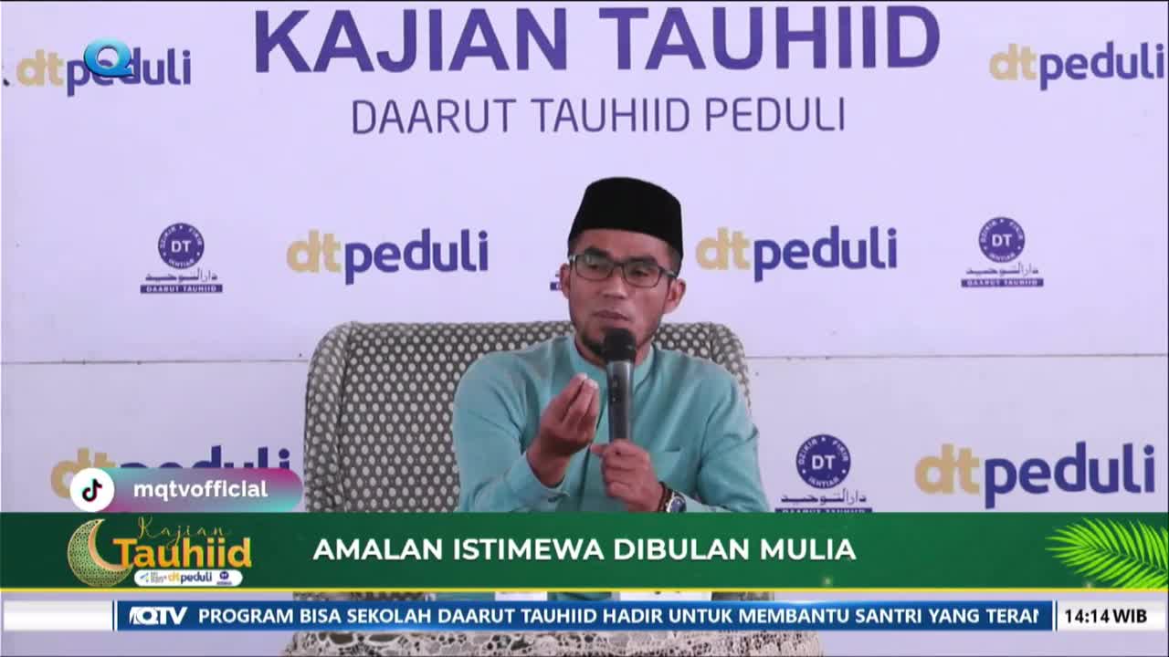 A man in a teal shirt and black peci is speaking into a microphone, gesturing with his hands. The backdrop behind him features the words "KAJIAN TAUHIID" and "DAARUT TAUHIID PEDULI" repeated.