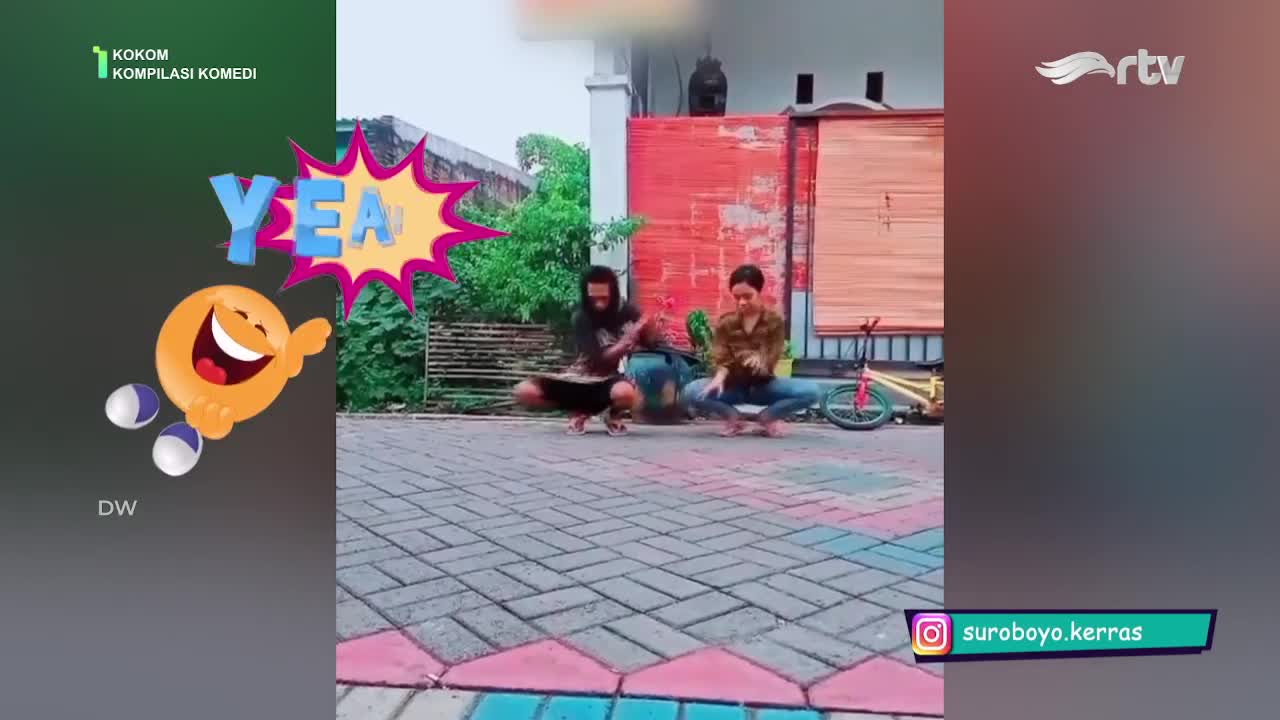 Two men are squatting on the pavement, moving their arms and bodies in a synchronized dance. The scene is part of a comedy segment from Rajawali TV, with a cartoon graphic in the corner.
