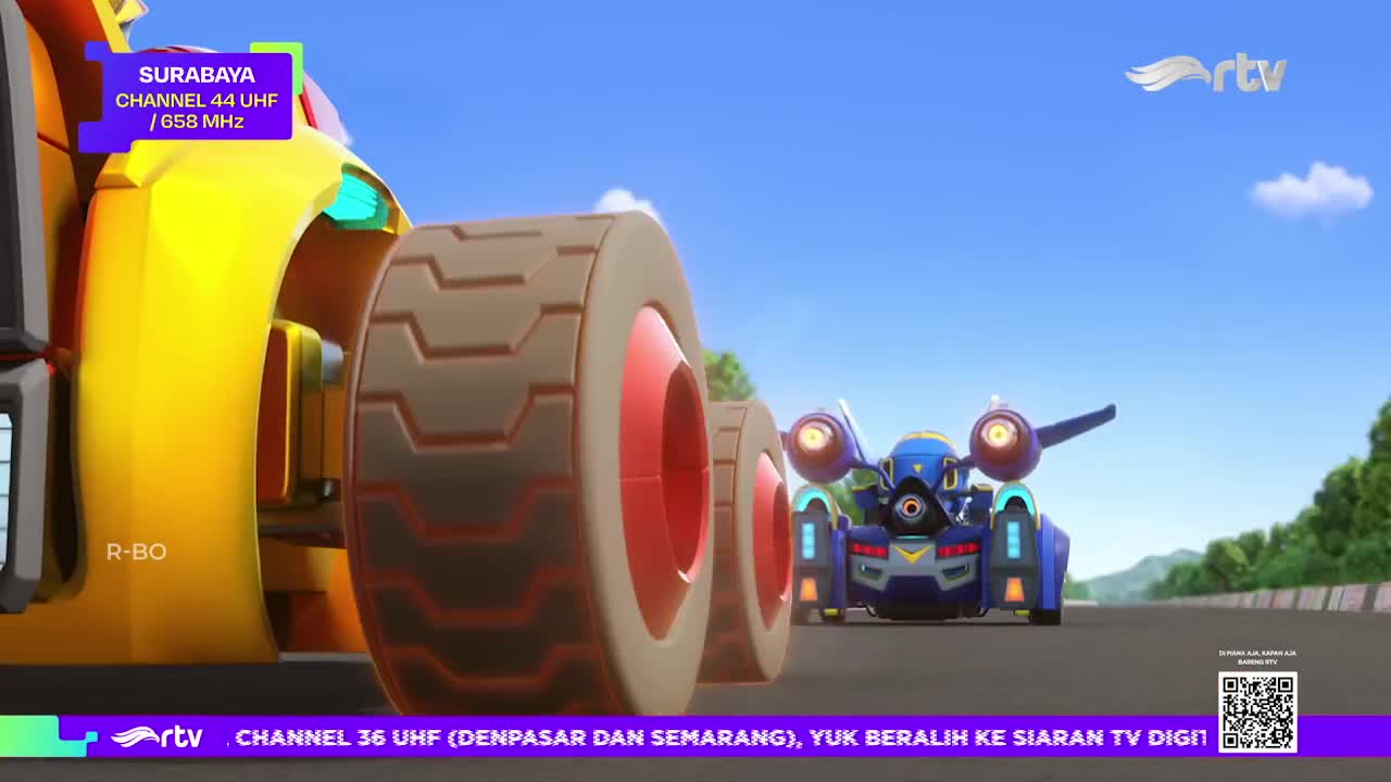 A bright yellow vehicle's wheel is in the foreground, while a blue and silver car speeds along the track on Rajawali TV. The scene is set in Indonesia, with the Surabaya channel information displayed on the screen.
