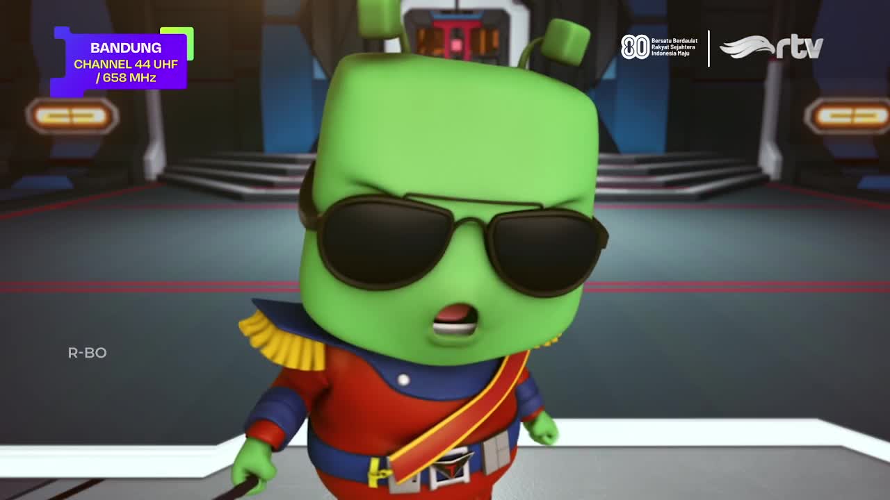 A green cartoon figure with sunglasses and a military-style outfit stares forward, mouth agape. The Rajawali TV logo is visible, and the Bandung channel information is displayed in the corner.
