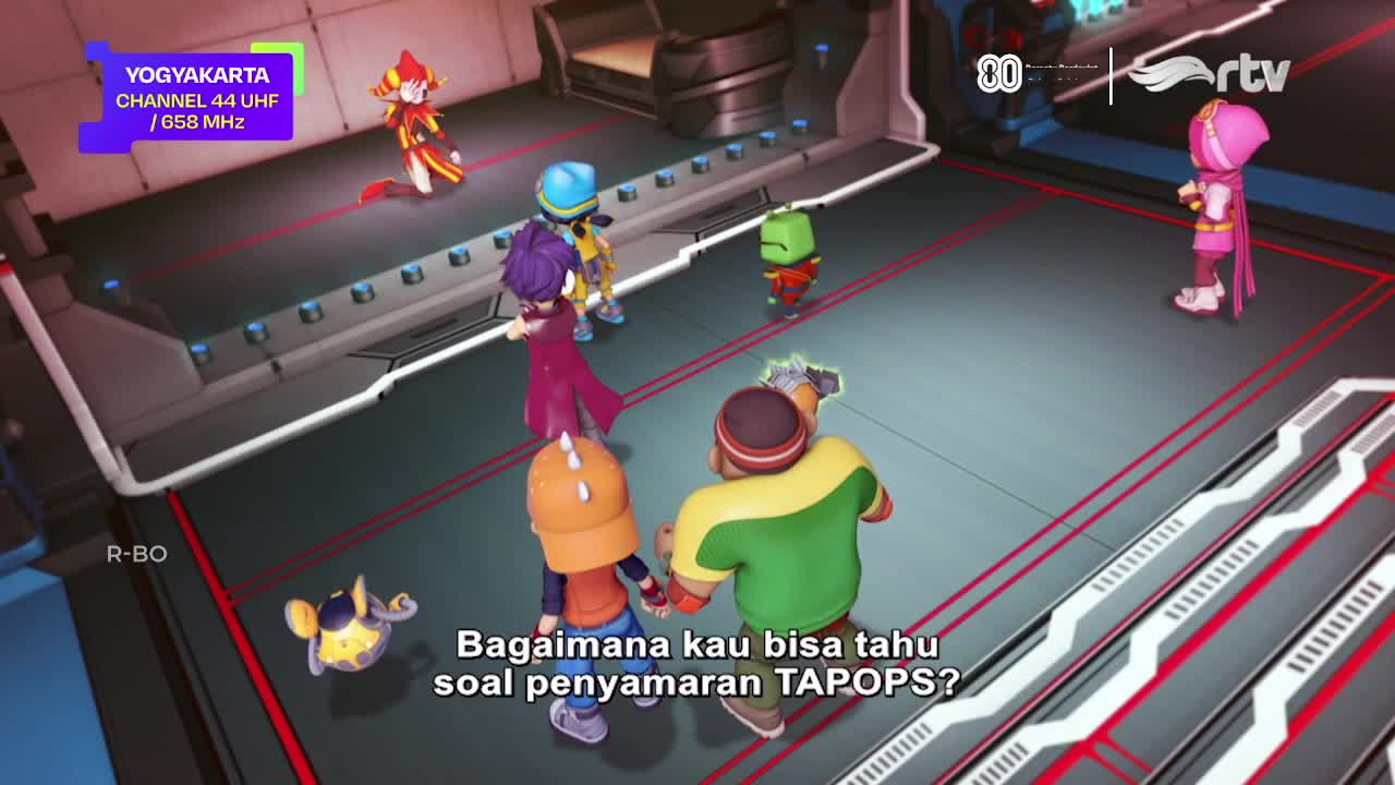 A group of animated characters are gathered on a metallic-looking floor, with one asking a question about TAPOPS, as seen on Rajawali TV. The scene is set in Yogyakarta, Indonesia, as indicated by the channel information in the corner.
