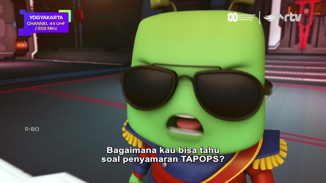 A green cartoon character with sunglasses is speaking, his mouth open in surprise. The Indonesian channel RTV logo is visible, along with a Yogyakarta broadcast frequency.
